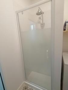 y baño con ducha y puerta de cristal. en Le Tréville Grand Studio Cosy 32M2, en Rochefort