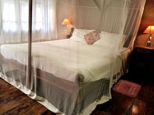 a bedroom with a large bed with white sheets at Neelchand in Canacona