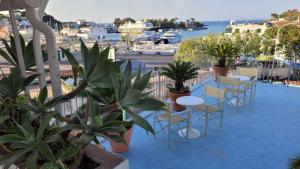 balcone con tavoli, sedie e vista sul porto di Villa Ciccio a Ischia