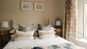 a bedroom with a white bed with pillows and a window at South View in Bakewell