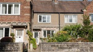 a brick house with white doors and windows at South View in Bakewell