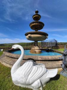 a statue of a swan in front of a fountain at SAUNTON GRANGE 7 Bedrooms in Braunton +56 photos