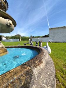 une fontaine d'eau entourée de cygnes. dans l'établissement SAUNTON GRANGE 7 Bedrooms, à Braunton
