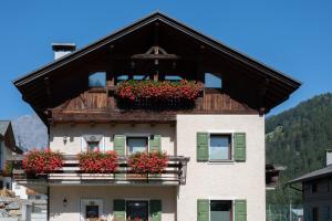 ein Gebäude mit Blumenkästen auf dem Balkon in der Unterkunft Casa Le Rondini in Valdisotto