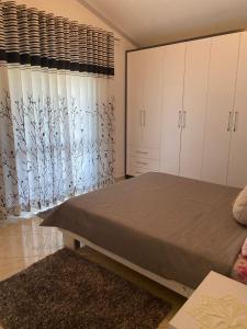 1 dormitorio con cama y ventana grande en Rooms for rent Gezim Ismailaj, 