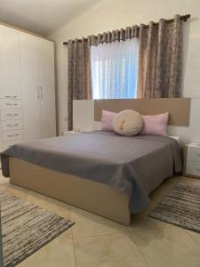 Un dormitorio con una cama con almohadas rosas y una ventana en Rooms for rent Gezim Ismailaj, 