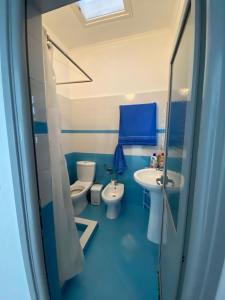 Baño azul con 2 aseos y lavamanos en Rooms for rent Gezim Ismailaj, 