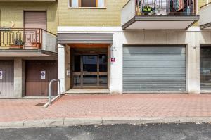 a building with a garage door on the side of a street at Kris- Mestre Bright Apartment with Parking! in Mestre