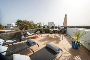 eine Terrasse mit Stühlen und Tischen auf dem Dach in der Unterkunft Villa LanzaCosta Golf in Teguise