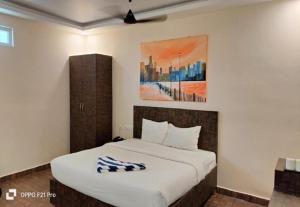 sypialnia z łóżkiem i obrazem na ścianie w obiekcie Royal Destiny Resort w mieście Malaiyāndipattanam