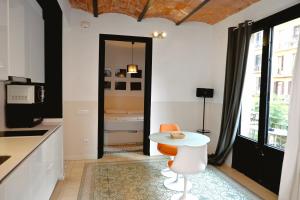 une cuisine avec une table et une chaise blanches dans l'établissement Homenfun Barcelona Sagrada Familia Marina, à Barcelone