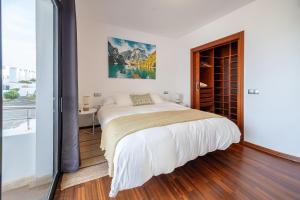 a white bedroom with a bed and a large window at Villa LanzaCosta Golf in Teguise +33 photos