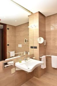 a bathroom with a sink and a mirror at DoubleTree by Hilton Turin Lingotto in Turin