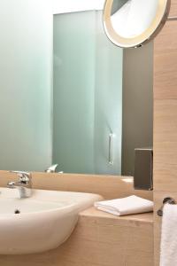 a bathroom with a white sink and a mirror at DoubleTree by Hilton Turin Lingotto in Turin