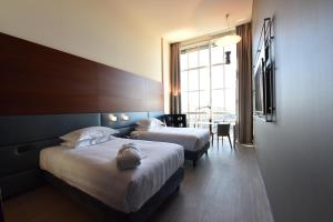 a hotel room with two beds and a table at DoubleTree by Hilton Turin Lingotto in Turin
