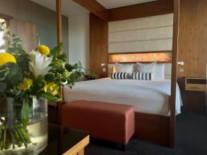 ein Hotelzimmer mit einem Bett und einer Vase aus Blumen in der Unterkunft The Gateway Hotel in Dundalk