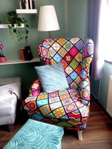 a chair with a quilt on it in a living room at FeWo Am alten Holzplatz in Drübeck