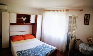 a bedroom with a bed and a window at Apartment Karlobag/Velebit Riviera 34907 in Karlobag