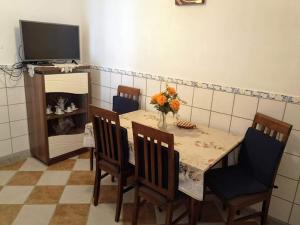 a dining room with a table with chairs and a television at Apartment Karlobag/Velebit Riviera 34907 in Karlobag
