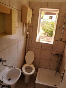a bathroom with a toilet and a sink and a window at Apartment Karlobag/Velebit Riviera 34907 in Karlobag