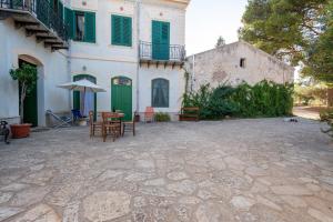 カステッランマーレ・デル・ゴルフォにあるCasina ai Fraginesiの建物の前にパティオ(テーブル、傘付)