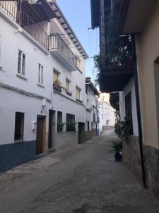 an empty alley with white buildings on a street at El Nido, Casa Rural in Casas del Castañar