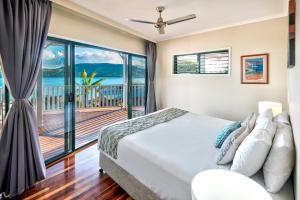 a bedroom with a bed and a balcony at Casuarina Cove 14 & Buggy - Hamilton Island in Hamilton Island