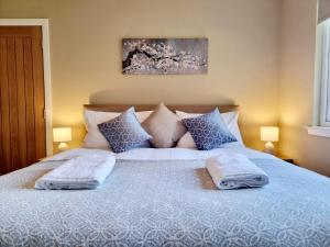 a bedroom with a bed with two towels on it at Muirton Cottage in Brechin