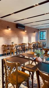 um restaurante com mesas e cadeiras e uma parede de tijolos em POUSADA CAFÉ DU'LIRIO em Lagoa Nova