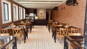 a restaurant with wooden tables and chairs and a brick wall at POUSADA CAFÉ DU'LIRIO in Lagoa Nova