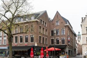 un grand bâtiment en briques avec des parasols rouges dans une rue dans l'établissement The View - spacious 2 bdr appt in with view, à Anvers
