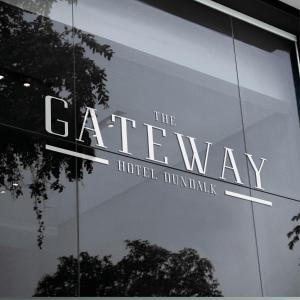 ダンドークにあるThe Gateway Hotelのホテルの玄関口の看板が付いたガラス張りの建物