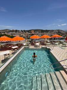 a person in a swimming pool with orange umbrellas at Barceló Carmen Granada in Granada