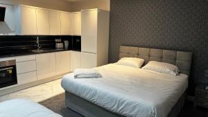 a bedroom with a large bed with white cabinets at OYO Cheetham Hill Guest House in Manchester