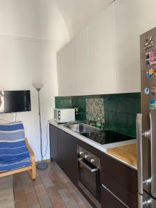 a kitchen with a sink and a refrigerator at La Masa Apartment in Palermo