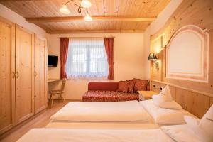 - une chambre avec deux lits et un canapé dans l'établissement App Lisüra Cir, à Corvara in Badia