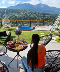 una mujer sentada en una mesa con un plato de comida en Cabana Ana en Borşa