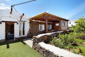 een huis met een stenen muur naast een tuin bij Ca Lajares in Lajares