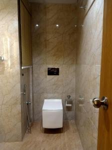 Un baño con inodoro y ducha en Hilarity Inn, en Padappai 24 fotos más