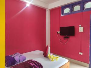 a room with a red wall and a tv at Hotel Zambala in Dirang Dzong