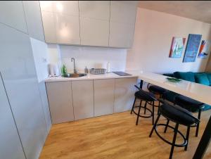 une cuisine avec un comptoir et des tabourets dans une pièce dans l'établissement Gondola 79, à Zlatibor 6 autres photos