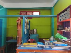 a room with green walls and a shelf with books at Hotel Zambala in Dirang Dzong