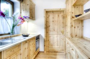 a kitchen with wooden cabinets and a sink at Family and Wellness Residence Ciasa Antersies in San Cassiano +65 photos
