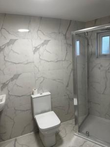 a bathroom with a toilet and a shower at OYO Cheetham Hill Guest House in Manchester