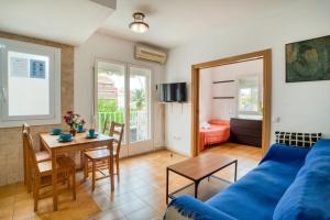 Una sala de estar con un sofá azul y una mesa. en Apartament Luisa, en Lloret de Mar
