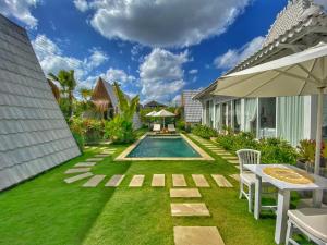 une arrière-cour avec piscine et pelouse dans l'établissement Piramida's White Villa's Bali - Joglo, à Canggu