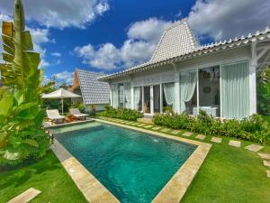 - une piscine en face d'une villa dans l'établissement Piramida's White Villa's Bali - Joglo, à Canggu