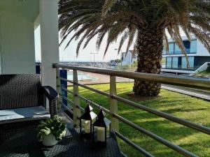 balkon z palmą i stołem ze świecami w obiekcie Marina Mar Vila Franca do Campo w mieście Vila Franca do Campo