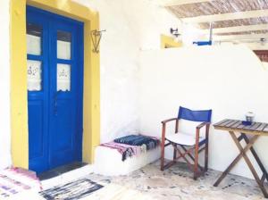 a room with a blue door and a chair and a table at Kaiti’s House in Arkoi