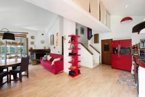 un soggiorno con mobili rossi e mensola rossa di Barcollo House - Piscina nel verde a Stella